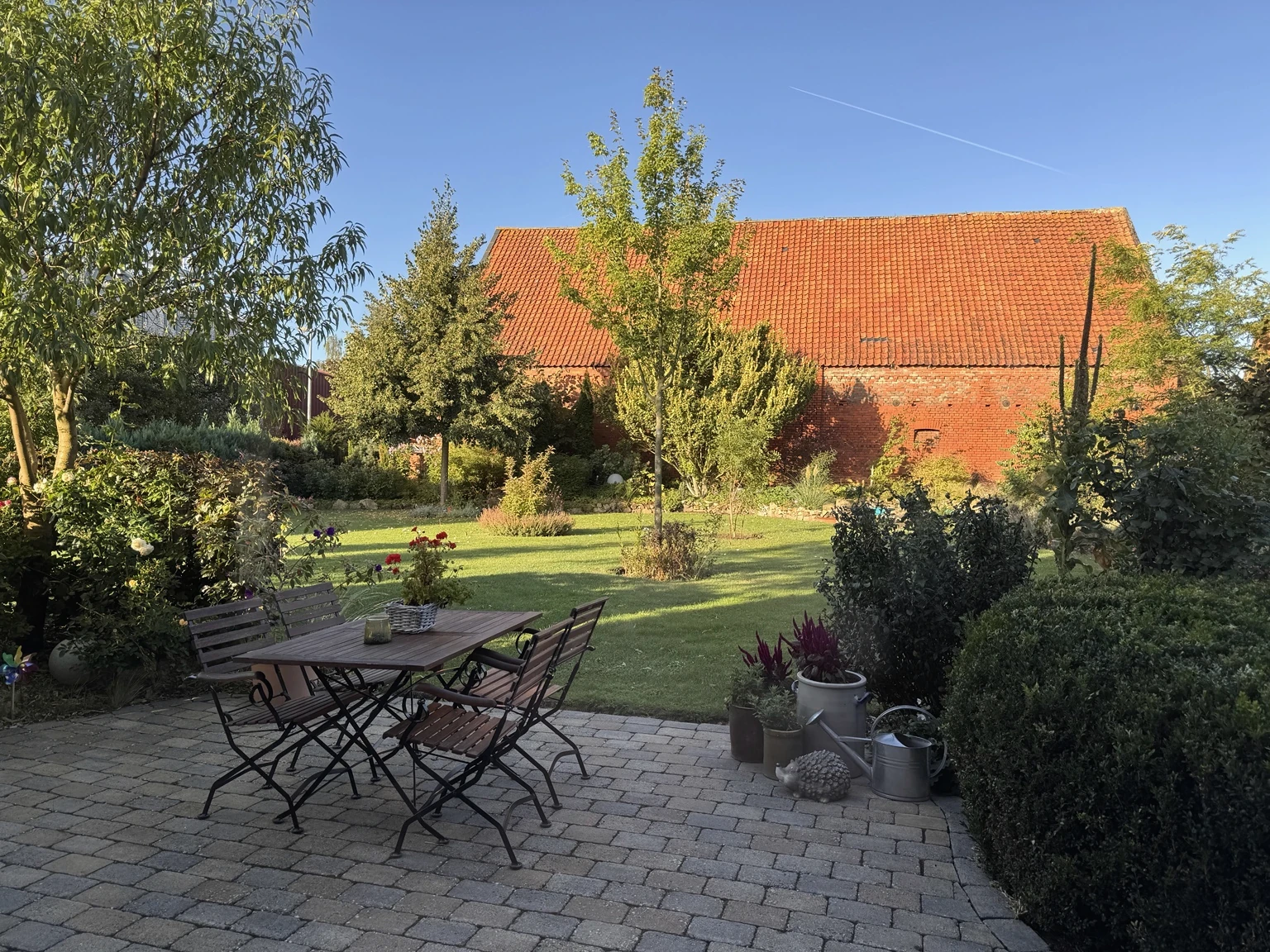 Echter Lebenshain-Garten mit Terrasse, gewachsener Bepflanzung und Blick in den Garten